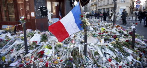 A French flag flies over flowers, candles and messages in tribute to victims outside "Le Carillon" restaurant a week after a series of deadly attacks in the French capital Paris, France, November 22, 2015. REUTERS/Charles Platiau - RTX1V9P9