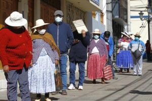 TOPSHOT - People in the Andean city of Puno, close to the border with Bolivia, queue outside a Pension Funds Administrator institution to request information about the withdrawal of up to the equivalent of 1,080 US dollars in national currency from their pension funds to alleviate the crisis caused by the confinement in force for two months to combat the Covid-19 coronavirus on May 19, 2020. - A law published on April 30, authorizes members of the private pension system to "voluntarily and extraordinarily, withdraw up to 25% of your total accumulated funds ", up to a maximum of 3,700 Peruvian Soles per person. More than six million Peruvians can request the withdrawal which economists have warned will have "long-term pernicious effects. (Photo by Carlos MAMANI / AFP)
